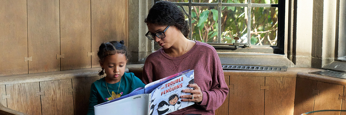 Mom reading to her son in the library