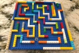 Marble maze made in multicolored Lego on a flat, blue Lego board.