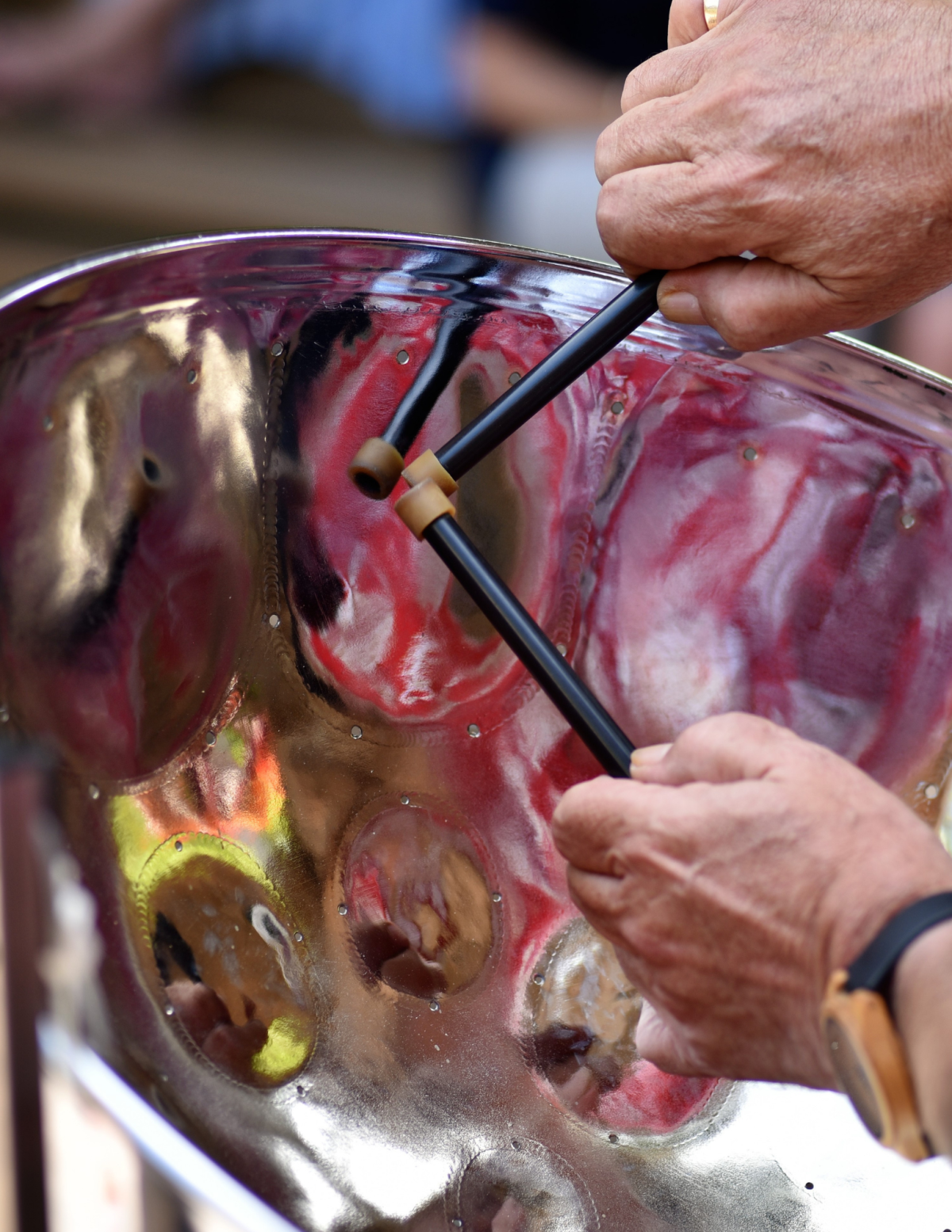 A close up image of hands playing a steel drum